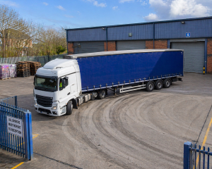 Well-organised warehouse yard with clear loading zones, parking, and vehicle circulation