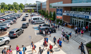 Busy sports facility entrance with parking and visitor flow showing peak usage and access considerations