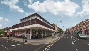 Mixed-use building with active commercial ground floor and residential units above in a town-centre setting.